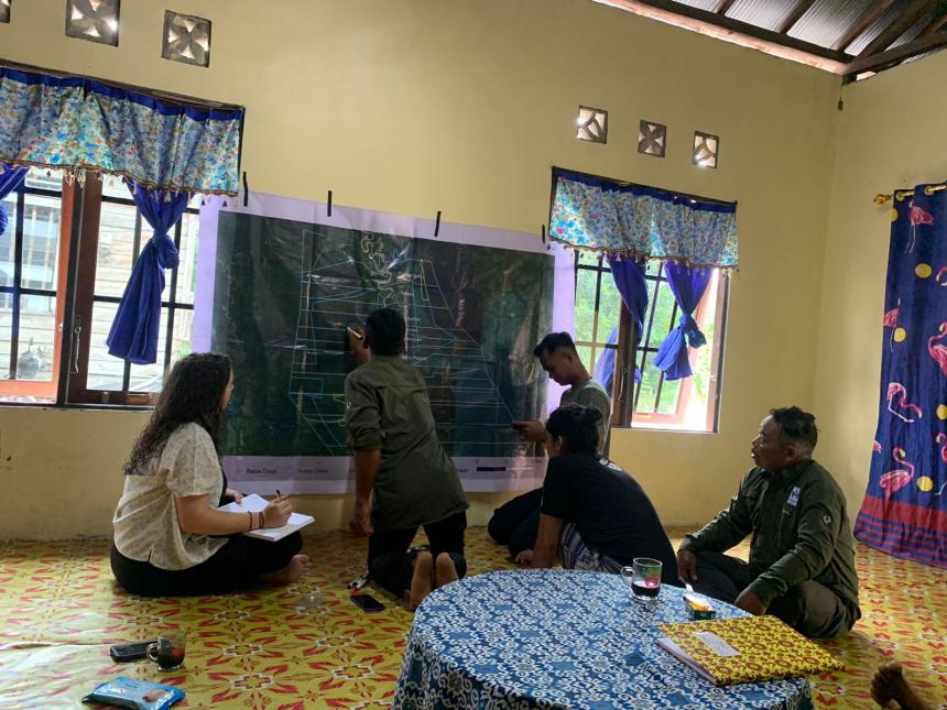 Five people sitting and drawing maps on a chalkboard